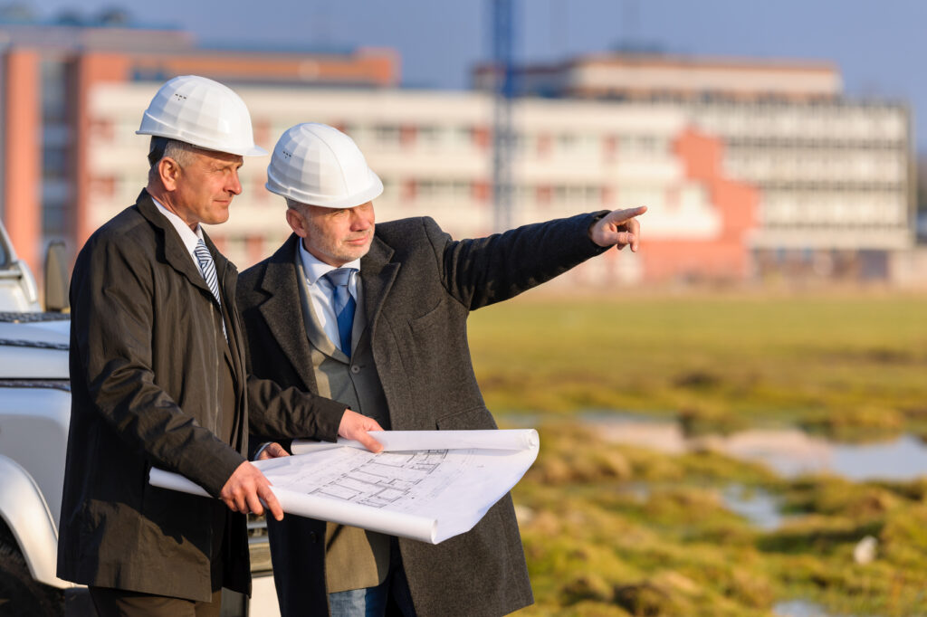 Two architects man point at construction site